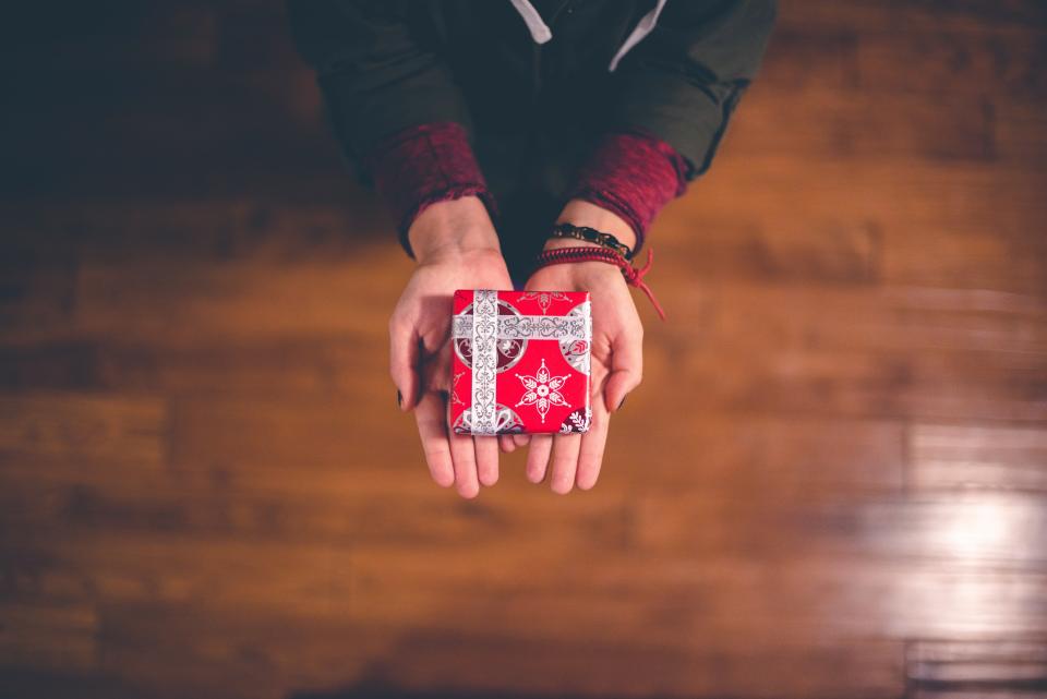 A wrapped gift passed between two people